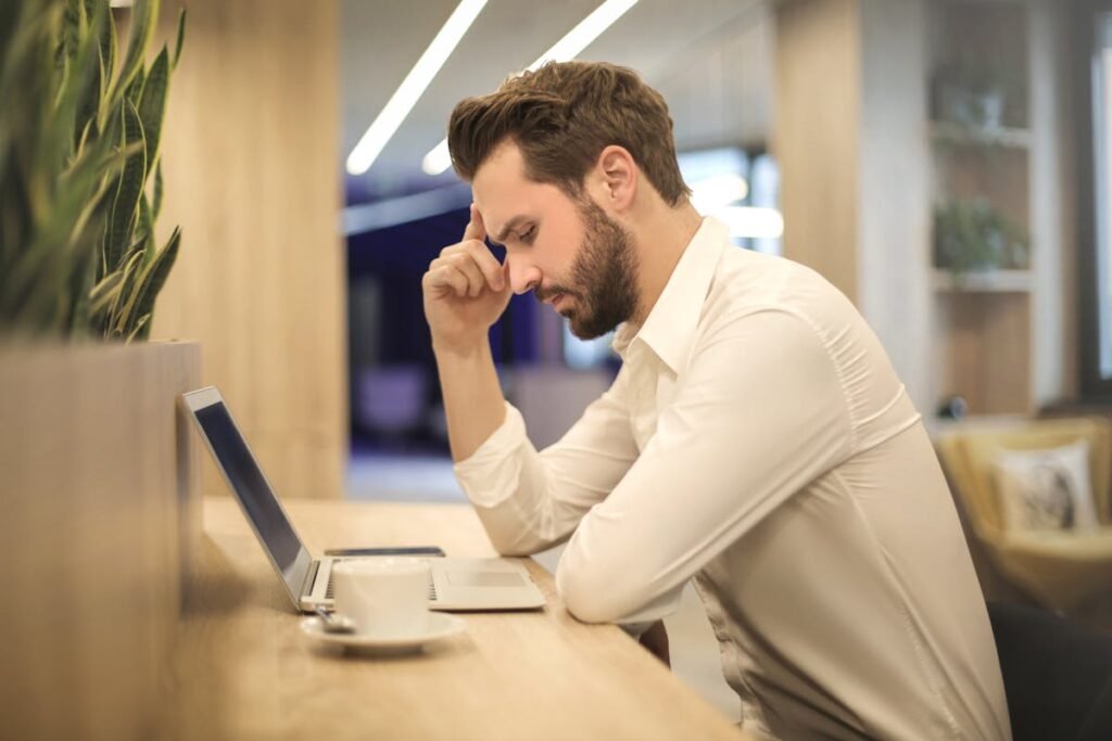 man is thinking in front of laptop