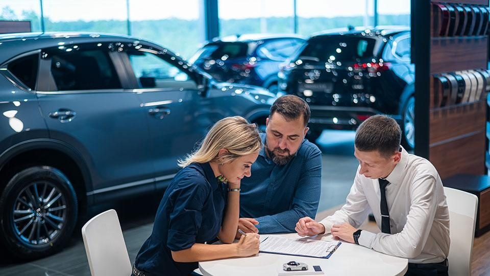 Car buyer reviewing vehicle financing paperwork at a dealership